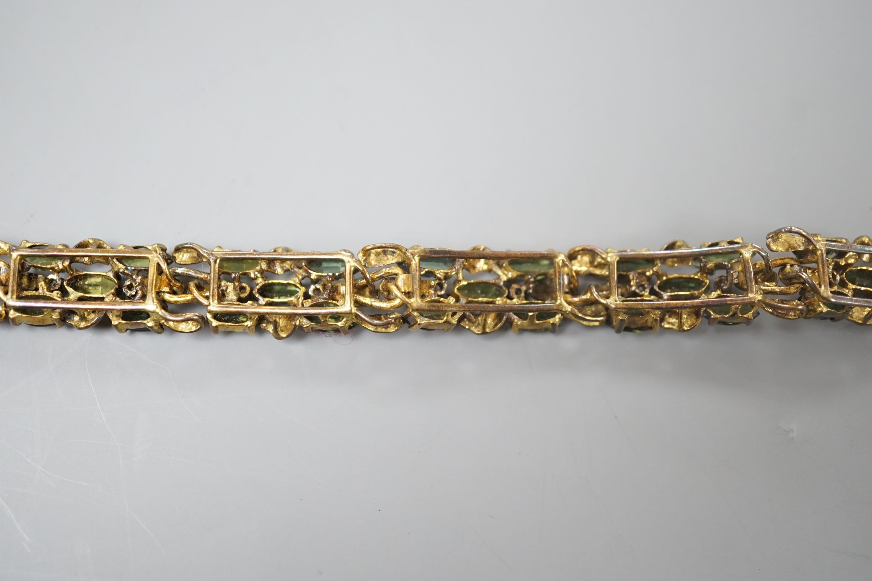 A modern yellow metal, multi green stone and multi diamond chip set bracelet, 16.5cm, gross weight 23.8 grams.